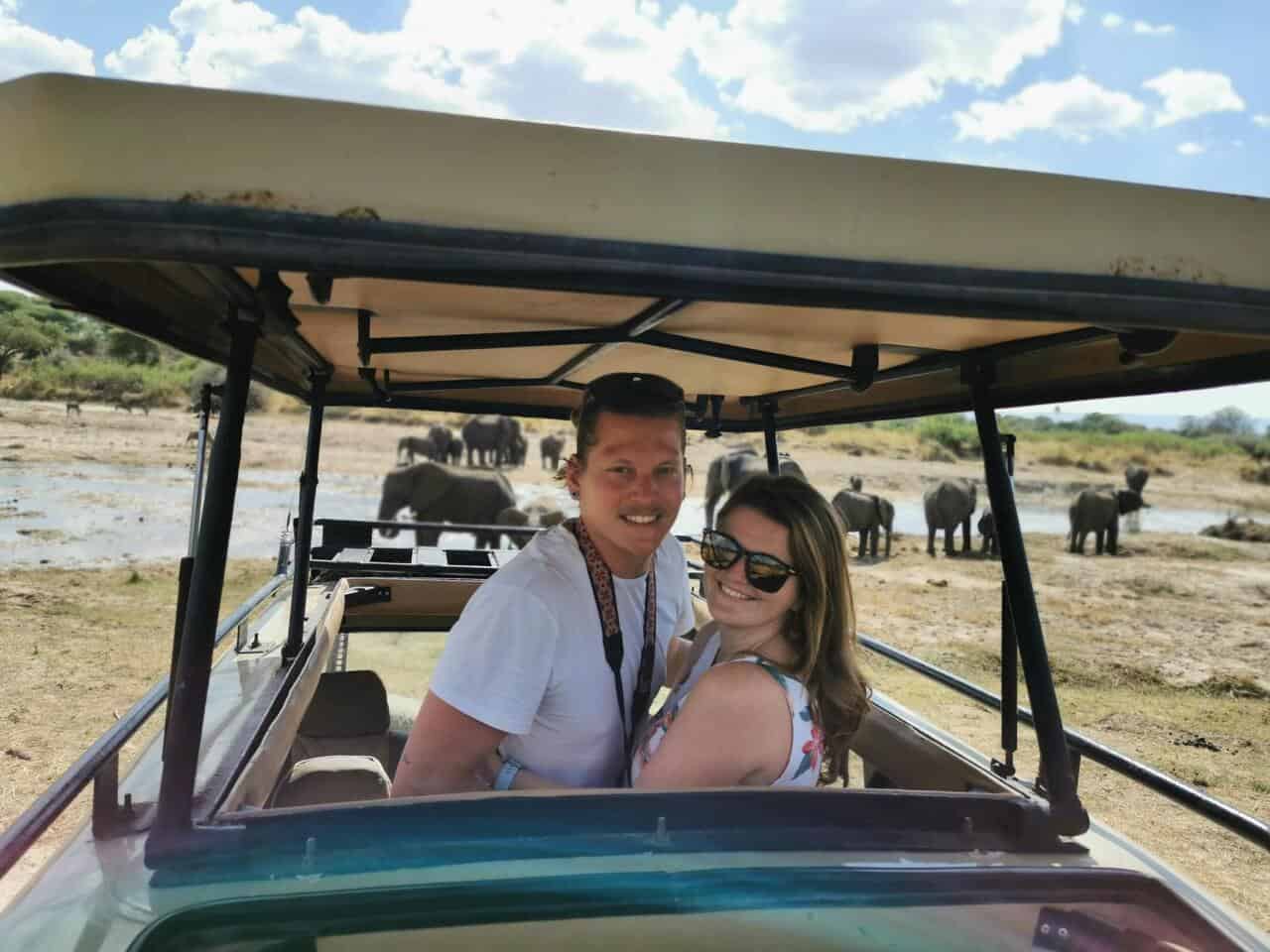 riding on safari jeep with elephants behind us