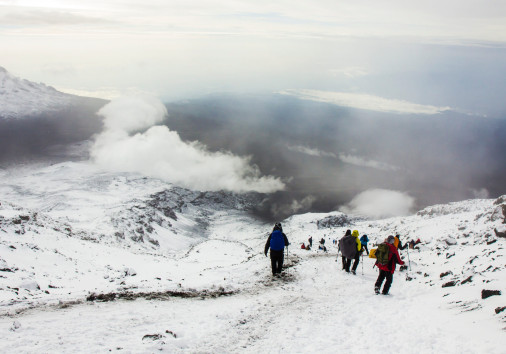 People Go Down From The Peak Of Kilimanjaro. Higher Than Clouds